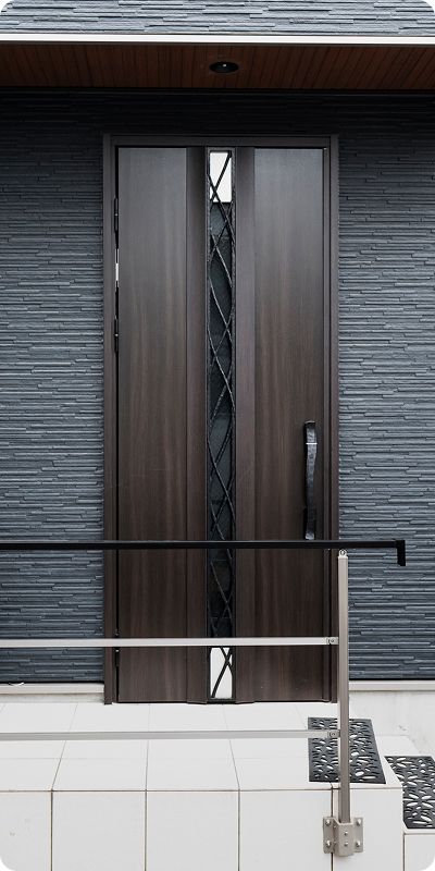 Close-up of dark wood modern double front door with vertical glass and iron grille